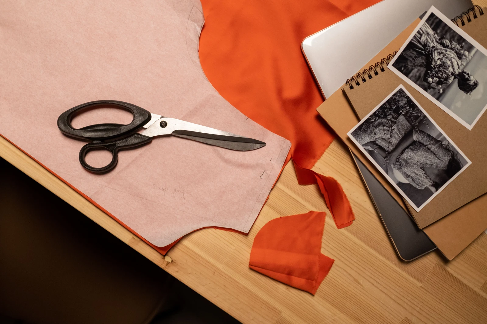 Fabric scissors and garment design references on a work table — representative stock photograph
